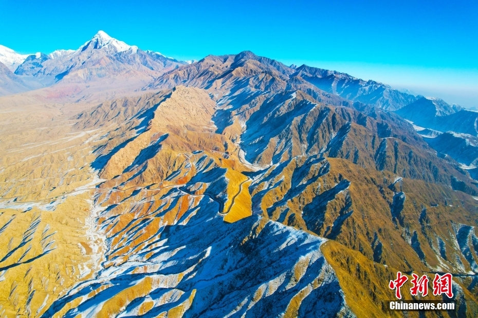 新疆阿克苏：库尔干山区雪后壮美巍峨 阳光下群山黄白相间