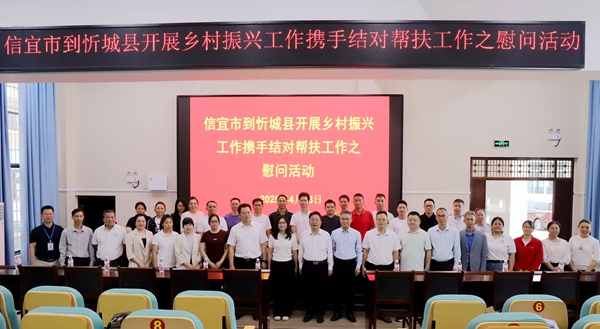 图为信宜市调研组与在忻城的信宜支医支教人员合影