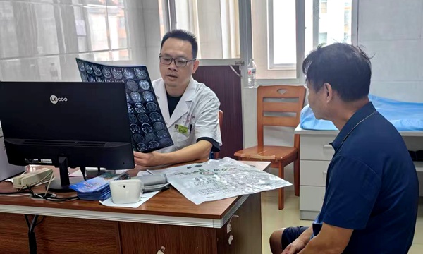 图为杨来医生为患者诊治