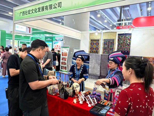 图为客商在忻城壮锦文创产品展位前驻足