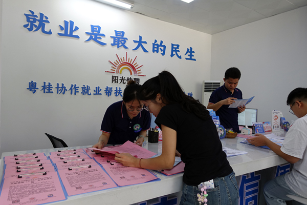 “阳光快聘”零工市场工作人员向求职者介绍企业用工信息。莫雪丽摄