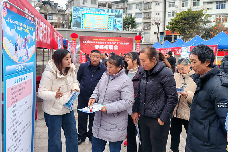 企业工作人员正在给求职者介绍企业相关资料。